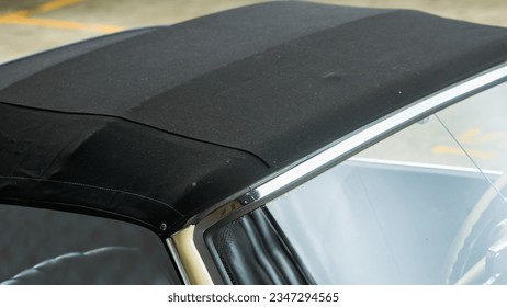Black convertible top on a car meeting the windshield