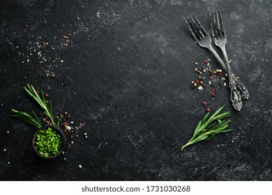 Black cooking background. Rosemary and spices on a black stone table. Top view. Free space for your text. - Powered by Shutterstock