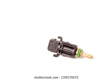 Black Coolant Temperature Sensor On A White Background With Yellow Metal Elements. The Engine Control Unit Corrective Composition Of The Air-fuel Mixture, The Engine Idle Speed, The Ignition Timing.