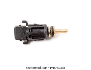 Black Coolant Temperature Sensor On A White Background With Yellow Metal Elements. The Engine Control Unit Corrective Composition Of The Air-fuel Mixture, The Engine Idle Speed, The Ignition Timing.