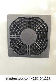 A Black Cooling Fan Sits On A White Steel Cabinet.