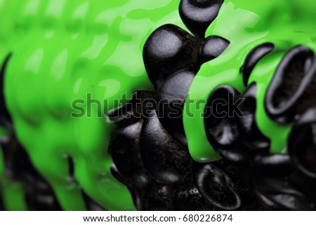 Black corn with pouring green paint background, macro closeup.Texture.Selective focus
