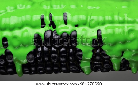 Black corn with pouring green paint background, macro closeup.Texture