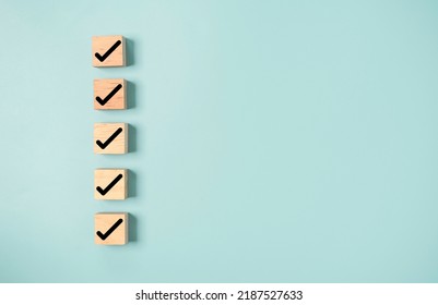 Black correct sign and tick check mark to wooden cube block with copy space for checklist of ISO quality control and approve business product concept. - Shutterstock ID 2187527633