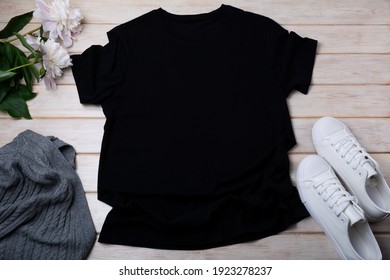 Black women’s cotton T-shirt mockup with gray aran sweater, white sneakers and pale pink peony. Design t shirt template, tee print presentation mock up