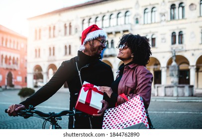 Black couple with bicycles walk around shops for Christmas presents. Christmas shopping.