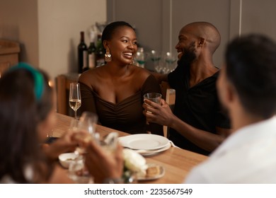 Black couple, champagne and party celebration with friends for new years, Christmas or social holiday event dinner at house. Man and woman talking and happy with alcohol glass to celebrate at night - Powered by Shutterstock