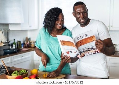 Black couple cooking in the kitchen together - Powered by Shutterstock