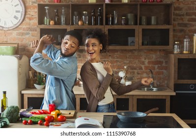 Black Couple Dancing Near Table With Food In Kitchen. Family Having Fun While Cooking