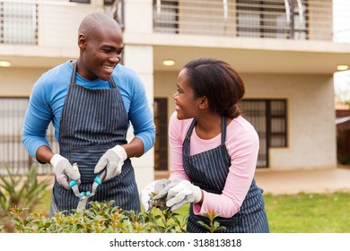 Black Couple Gardening In Front Yard