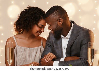 Black Couple In Love Cuddling At Restaurant While Having Date, Drinking Champagne, Close Up