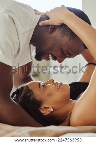 Black couple, love and home bedroom romance while happy and intimate together on bed at home, apartment or hotel. Face of young man and woman in happy marriage with commitment and care on honeymoon