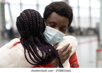 Black Couple Met In Airport After Separation Due To Covid Lockdown. Romantic Man In Mask Woman Give Warm Hug. Happy African Family Reunion. Millennial Man Welcome Woman Home From Travel In New Normal