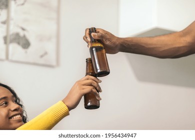 black couple toasting beer at home. - Powered by Shutterstock