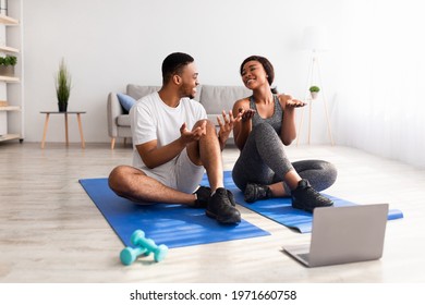 Black Couple Watching Online Video Sports Tutorial On Laptop, Taking Break From Domestic Training, Talking To Each Other. Fit Young Guy And His Girlfriend Speaking To Personal Trainer On Web At Home