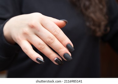 Black Creative Manicure Polish On Beautiful Female Hand. Dark Nail Gel. Beauty Salon Procedures For Hand Nails. Black Nail Polish Close Up.