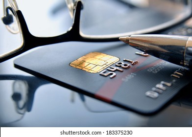 Black credit card with glasses and ballpoint