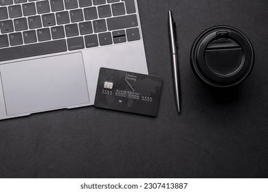 Black credit card on office table with laptop and coffee cup. Flat lay with copy space. Premium banking concept - Powered by Shutterstock