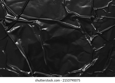 black crumpled and creased plastic poster texture background