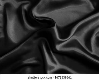 Black crumpled fabric background.. Liquid wavy shape.