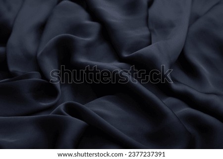 Black crumpled fabric folds background.  Black history month concept. Soft focus texture of the silk fabric, soft black.