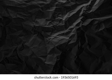 Tekstur kertas kusut hitam di latar belakang cahaya rendah
