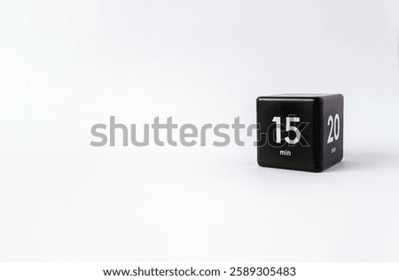 Black cube timer with 15 minutes sign on white background. Minimal interval time concept. Copy space, selective focus