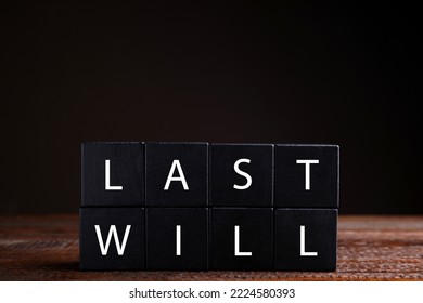 Black Cubes With Words Last Will On Wooden Table Against Dark Background