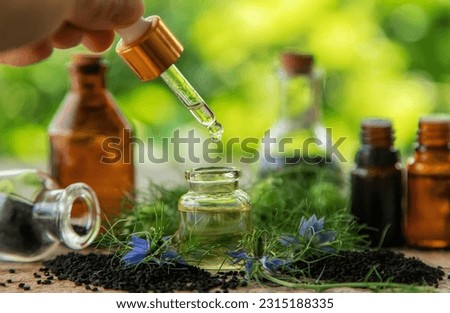 Black cumin oil in a bottle. Selective focus. Nature.
