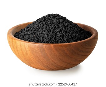 black cumin seeds in brown wooden bowl isolated on white background