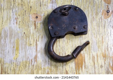 Black Cut Padlock On A Shabby Wooden Background.