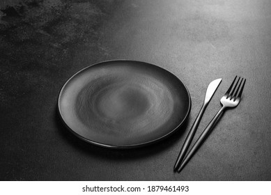 Black cutlery on a concrete dark table. Dining table preparation - Powered by Shutterstock