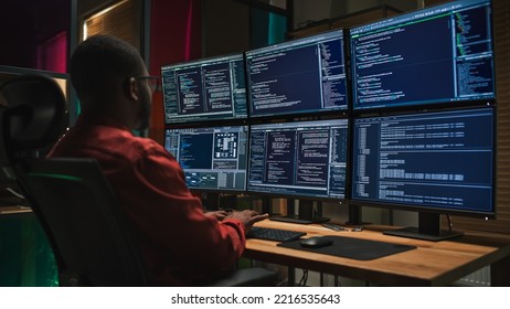 Black Cyber Security Specialist Coding on Desktop Computer With Six Monitors in Dark Office. African American Male Contractor Monitoring Data Protection System For Private Sector Clients. - Powered by Shutterstock