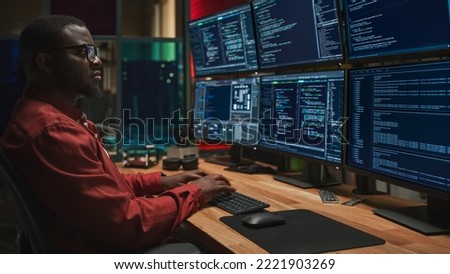 Black Cyber Security Specialist Coding on Desktop Computer With Six Monitors in Dark Office. African American Male Contractor Monitoring Data Protection System For Ministry Of Defence, Private Sector