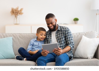 Black Dad And Son Using Digital Tablet Sitting At Home - Powered by Shutterstock