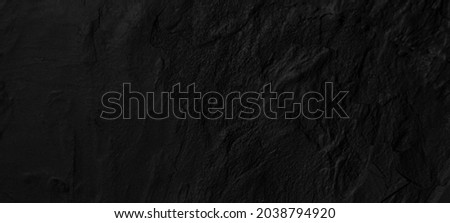 Black, dark abstract rock texture, interior for display products,stone wall background with copy space for design.