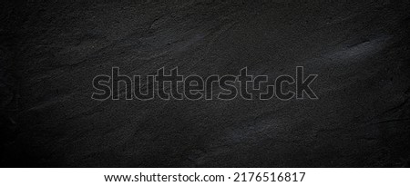 Black or dark gray rough grainy stone or sand texture background