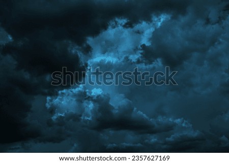 Black dark greenish blue dramatic night sky. Gloomy ominous storm rain clouds background. Cloudy thunderstorm hurricane wind lightning. Epic fantasy mystic. Or creepy spooky nightmare horror concept.