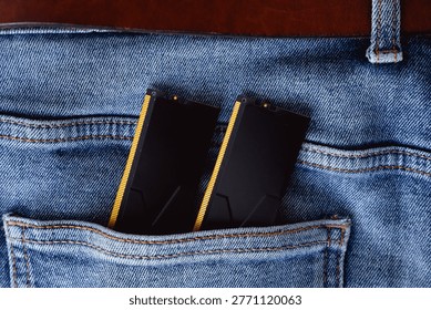 Black DDR5 RAM memory modules placed inside a jeans pocket. RAM shortages on the market, rising prices, and increased demand driven by the growing need for AI training.