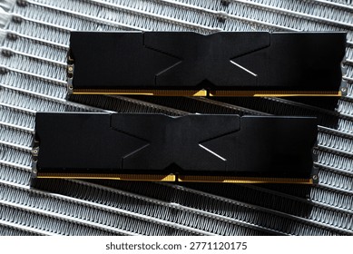 Black DDR5 RAM memory modules placed on a aluminum radiator. RAM shortages on the market, rising prices, and increased demand driven by the growing need for AI training.