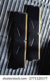 Black DDR5 RAM memory modules placed on a aluminum radiator. RAM shortages on the market, rising prices, and increased demand driven by the growing need for AI training.