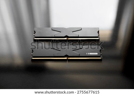 Black DDR5 RAM memory modules placed on a dark, glossy surface. RAM shortages on the market, rising prices, and increased demand driven by the growing need for AI training.