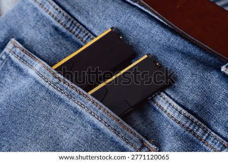 Black DDR5 RAM memory modules placed inside a jeans pocket. RAM shortages on the market, rising prices, and increased demand driven by the growing need for AI training.