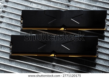 Black DDR5 RAM memory modules placed on a aluminum radiator. RAM shortages on the market, rising prices, and increased demand driven by the growing need for AI training.