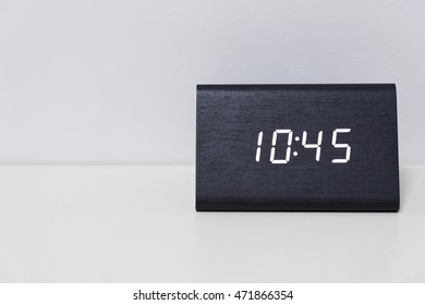 Black digital clock on a white background showing time 10:45 (ten hours forty-five minutes)
