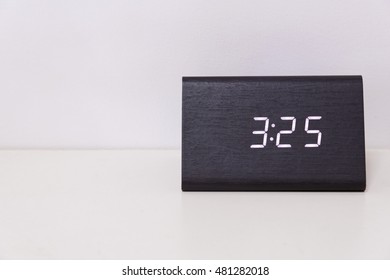 Black digital clock on a white background showing time 3:25 (Three hours twenty-five minutes)
