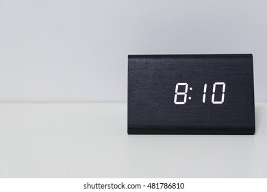 Black digital clock on a white background showing time 8:10 (eight hours ten minutes)