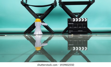Black director chair with clapperboard or movie clapper board and megaphone on green or Tiffany Blue or mint background.it use in videography or film cinema industry