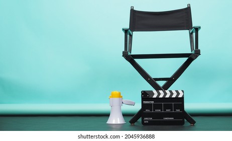 BLACK director chair with megaphone and Clapperboard or movie Clapper board on green or Tiffany Blue and black floor background.it use in video production or movie and cinema industry. 