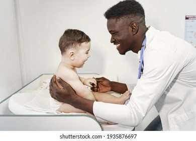 Black doctor. Baby in diaper. African with stethoscope.